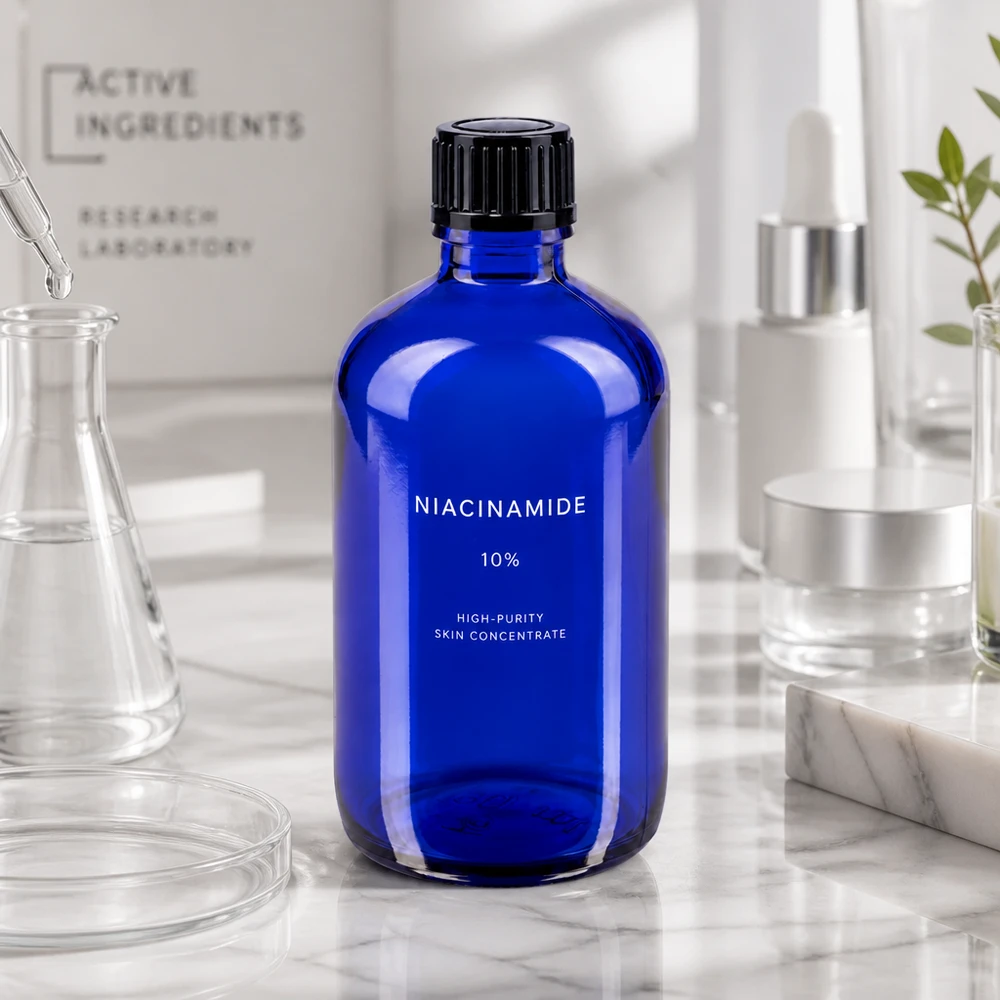 Flacon de pharmacie bleu 100ml bouchon compte-gouttes 1mm noir Std Flacon de pharmacie bleu cobalt de 100 ml, muni d'une étiquette « Niacinamide », sur un fond marbré, dans un décor de laboratoire
