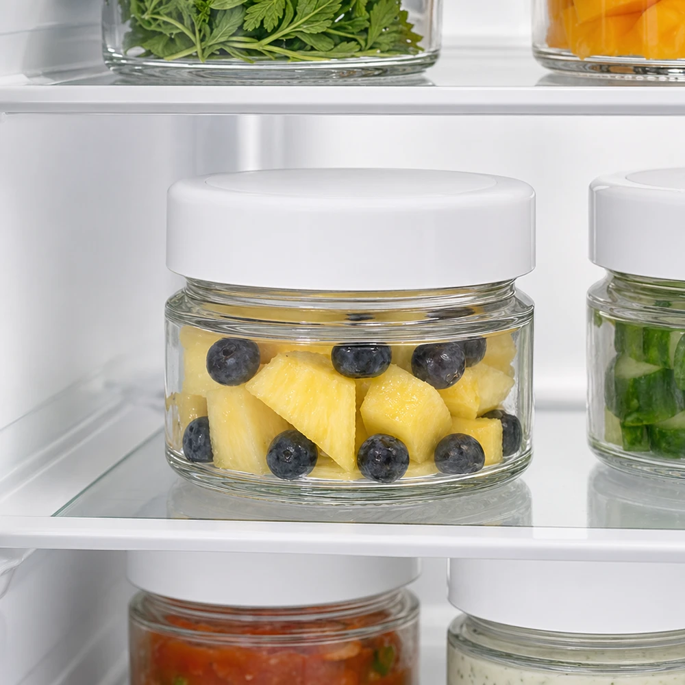 Un barattolo rotondo da 80 ml in frigorifero con ananas e mirtilli mostra le proprietà ottimali di conservazione della freschezza del coperchio BasicSeal
