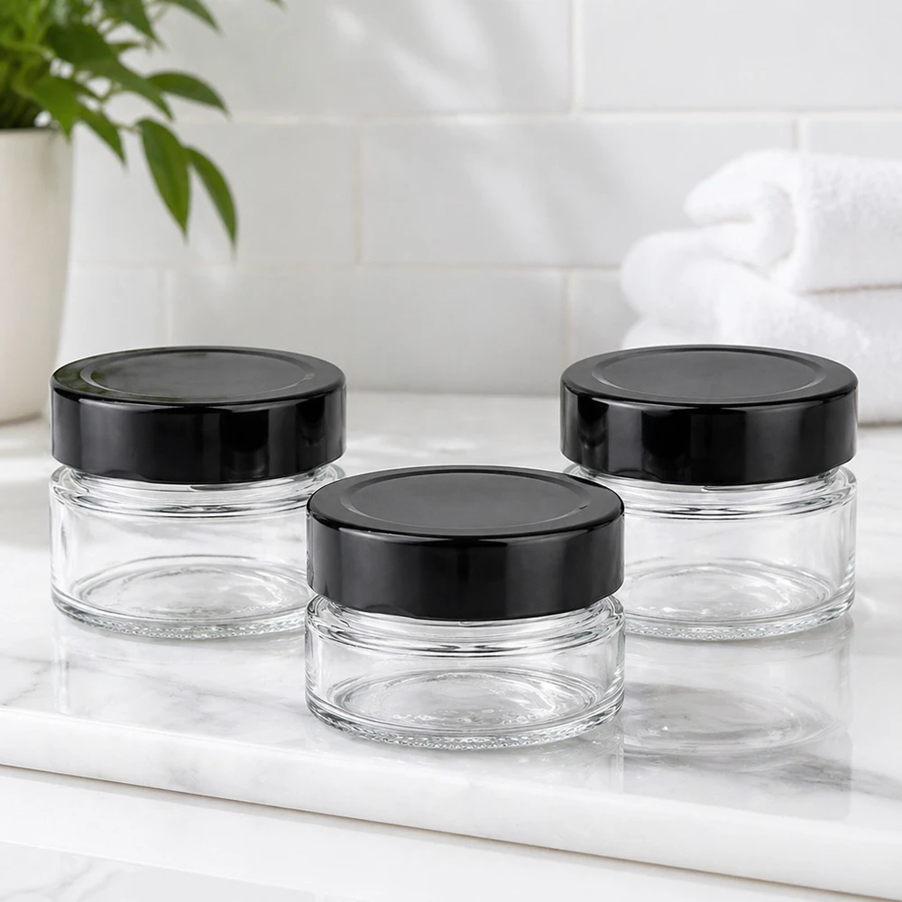 80ml Rundglas + BasicSeal Deckel schwarz deep UNiTWIST Drei 80ml Rundgläser mit schwarzen BasicSeal Deckeln UNiTWIST auf weißer Marmorplatte Badezimmer Ambiente leer
