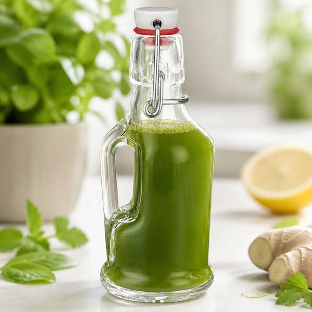 Bottiglia di vetro Bertha 200ml riempita di frullato verde accanto a zenzero e limone Scena di cucina UNiTW swing top