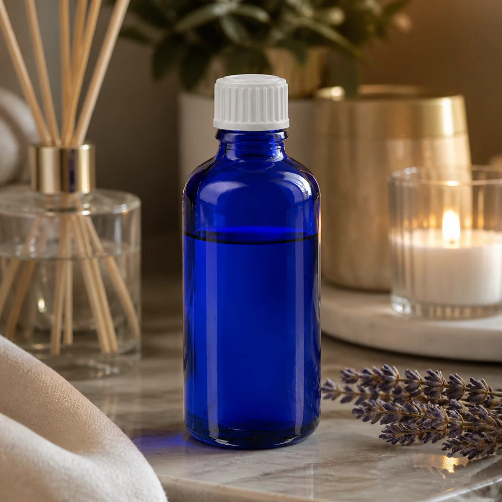 Flacon à pharmacie bleu 50ml bouchon compte-gouttes blanc 0.8mm std Flacon en verre bleu de 50 ml muni d'un bouchon compte-gouttes, posé sur du marbre à côté de la lavande et d'un diffuseur de parfum d'ambiance