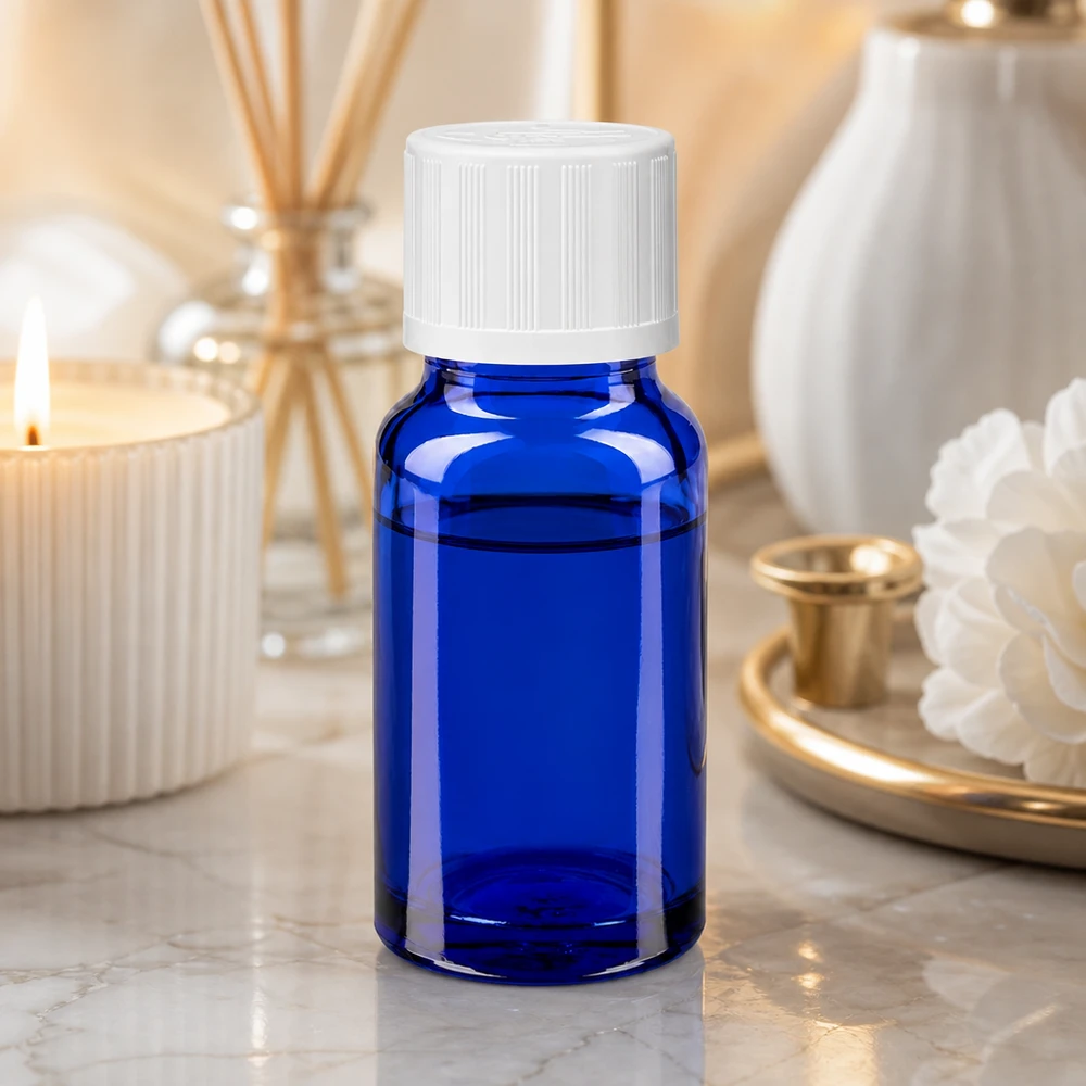 Apothekenflasche blau 10ml Tropfverschluss weiß Kindersicherung Standard Kompakte kobaltblaue Tropfflasche mit weißem Dosierverschluss vor goldfarbenem Tablett und Vase