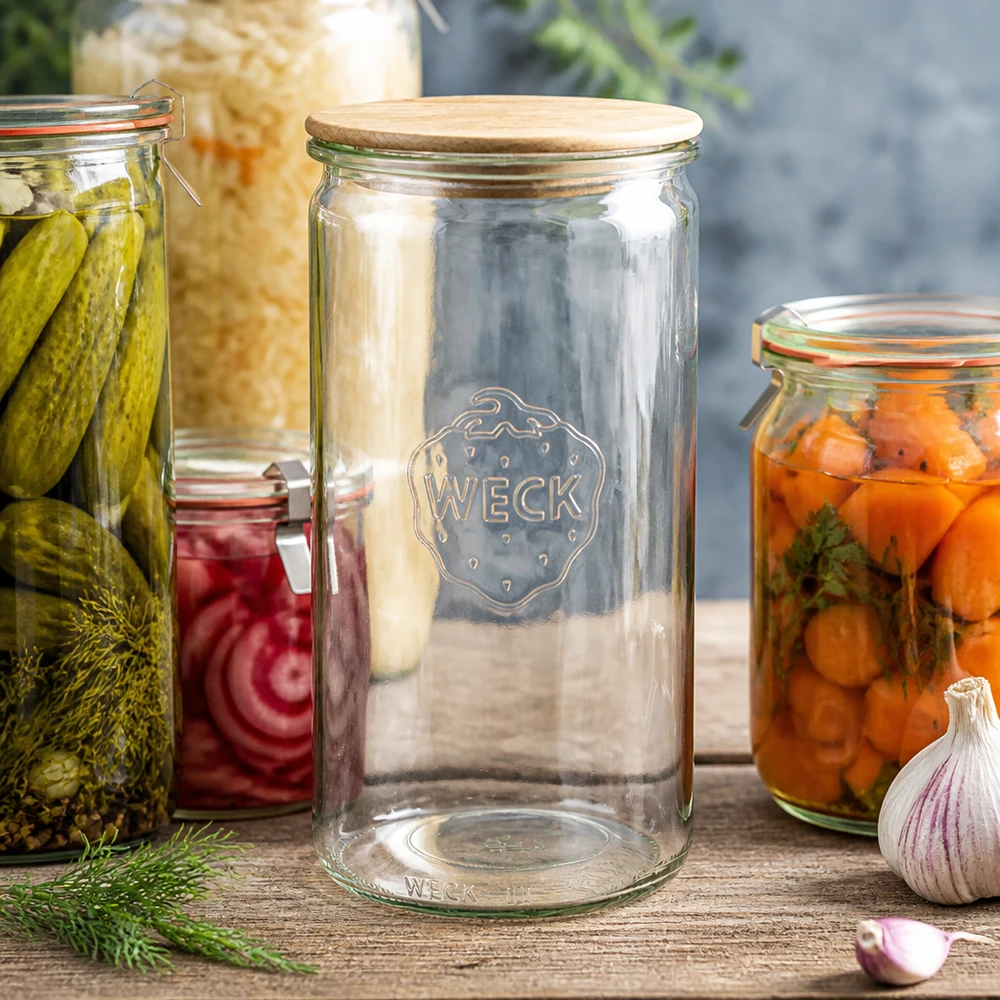 1590ml Zylinderglas WECK RR100 mit Holzdeckel WECK Zylinderglas 1590ml RR100 mit Holzdeckel zwischen Einmachgläsern mit Gurken Karotten und Sauerkraut auf Holztisch