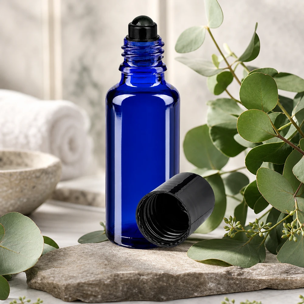 30ml Roll-On Gebinde aus blauem Borosilikatglas mit schwarzem Schraubverschluss auf Steinuntergrund