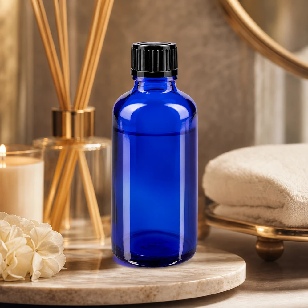 Flacon compte-gouttes bleu cobalt de 50 ml en verre d'apothicaire avec bouchon à vis noir, dans une ambiance spa
