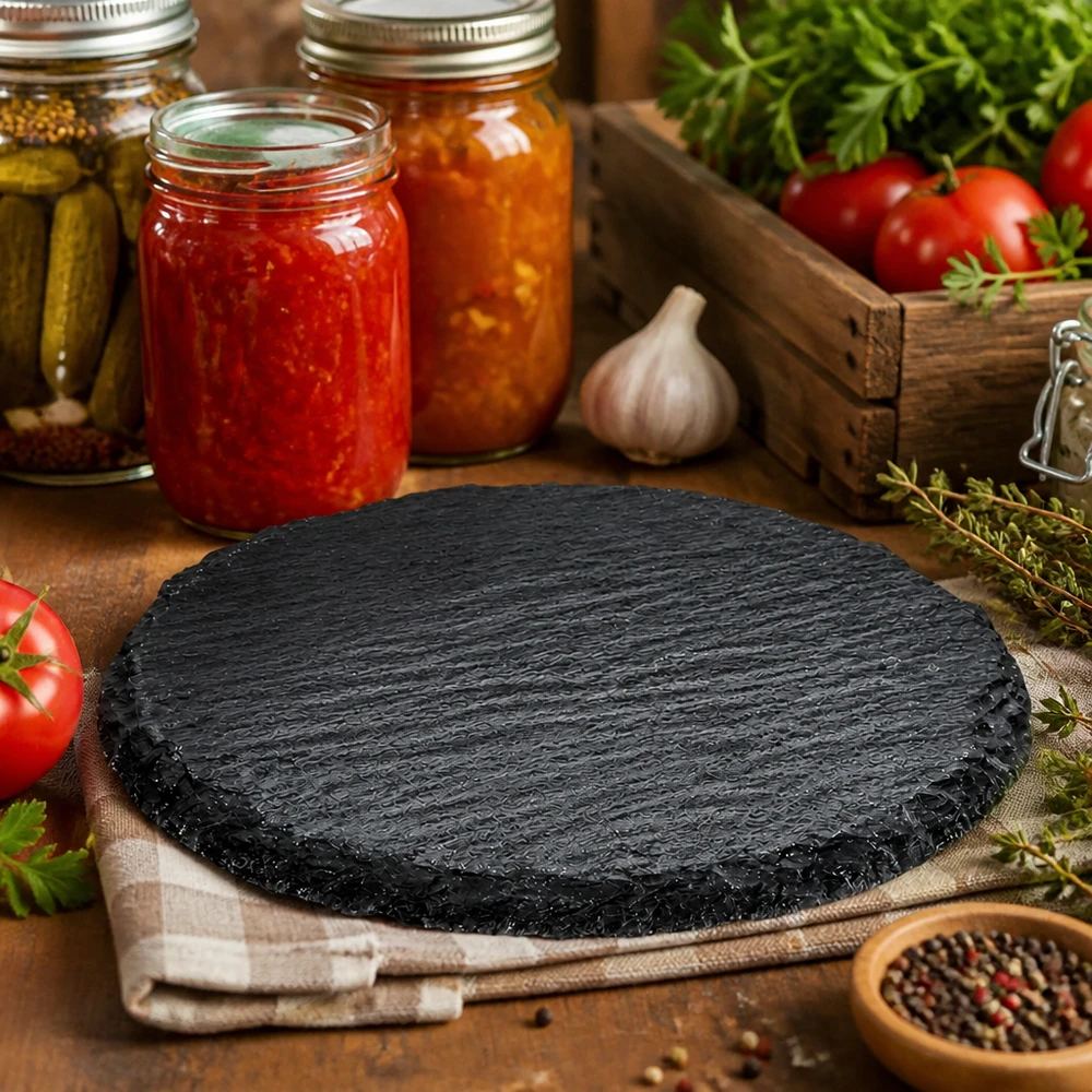 Servierplatte aus Schiefer rund ø150mm Runde Schieferplatte 150mm in rustikaler Küche dekoriert mit Einmachgläsern, Tomaten und Kräutern als Servierboard