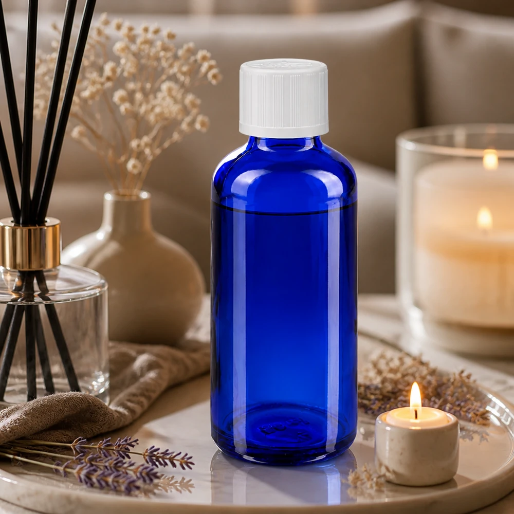 Flacon compte-gouttes de 50 ml en verre d'apothicaire bleu cobalt, muni d'un bouchon blanc à sécurité enfant, dans une ambiance bien-être