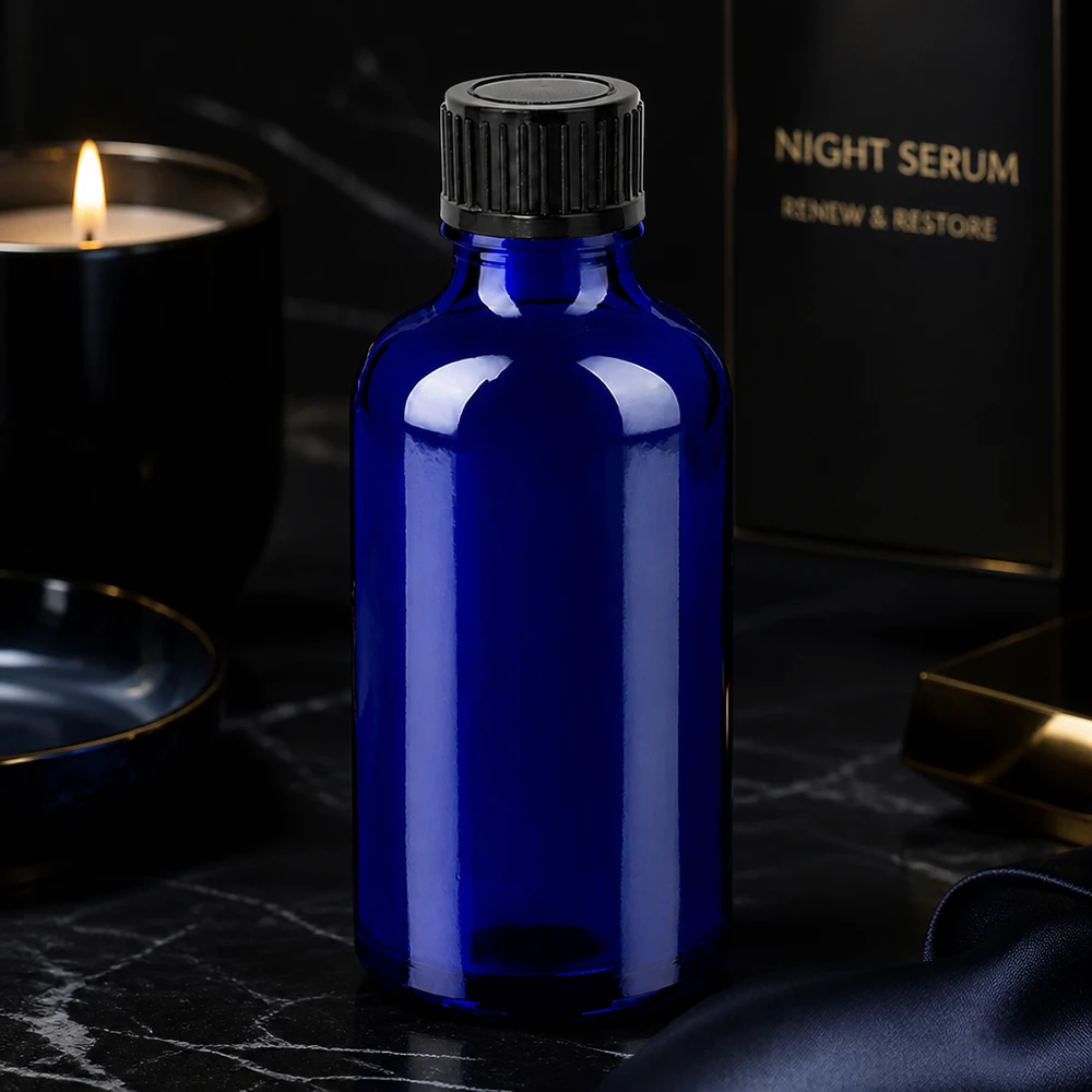 Flacone in vetro da 50 ml di colore blu intenso con coperchio nero per proteggere gli ingredienti dai raggi UV.