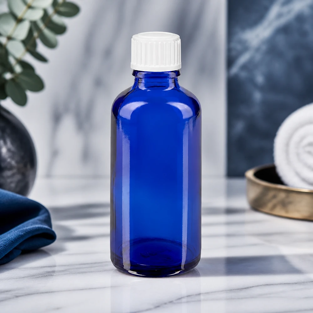 Flacon à pharmacie bleu 50ml bouchon compte-gouttes blanc 0.8mm std Flacon compte-gouttes STD de 50 ml bleu cobalt en verre ApoGlas, avec bouchon blanc, sur fond marbré