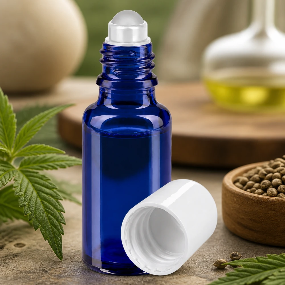 Blaue 20ml Rollerflasche aus UV-Schutzglas neben natürlichen Kräutern und Hanfsamen