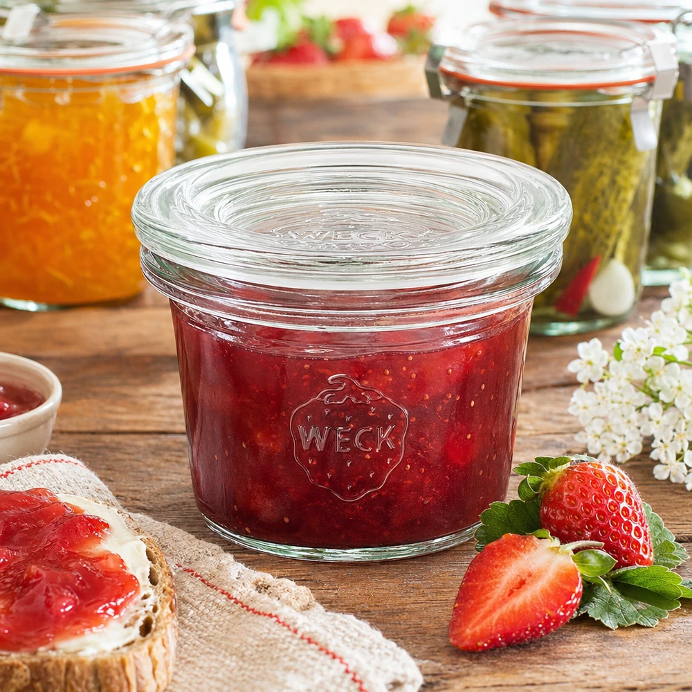 35ml Sturzglas mit Glasdeckel WECK RR40 WECK Sturzglas 35ml RR40 mit roter Erdbeermarmelade gefüllt neben frischen Erdbeeren und Marmeladenbrot
