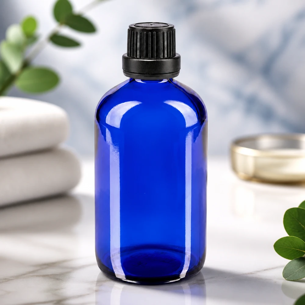 Flacon en verre bleu cobalt de 100 ml, muni d'un bouchon de sécurité noir pour enfants et d'un bec verseur de 2 mm