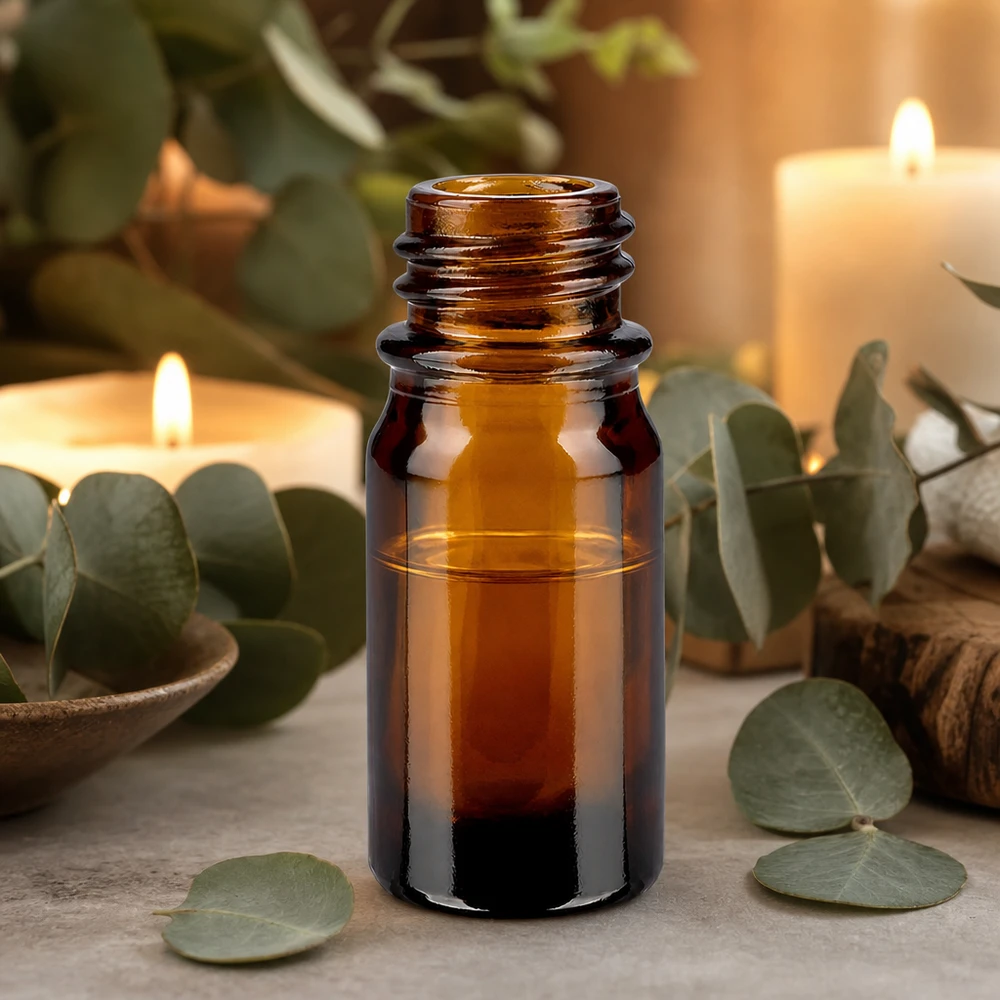 Flacone da 5 ml marrone da farmacia ApoGlas con foglie di eucalipto e candele per l'applicazione dell'aromaterapia rilassante